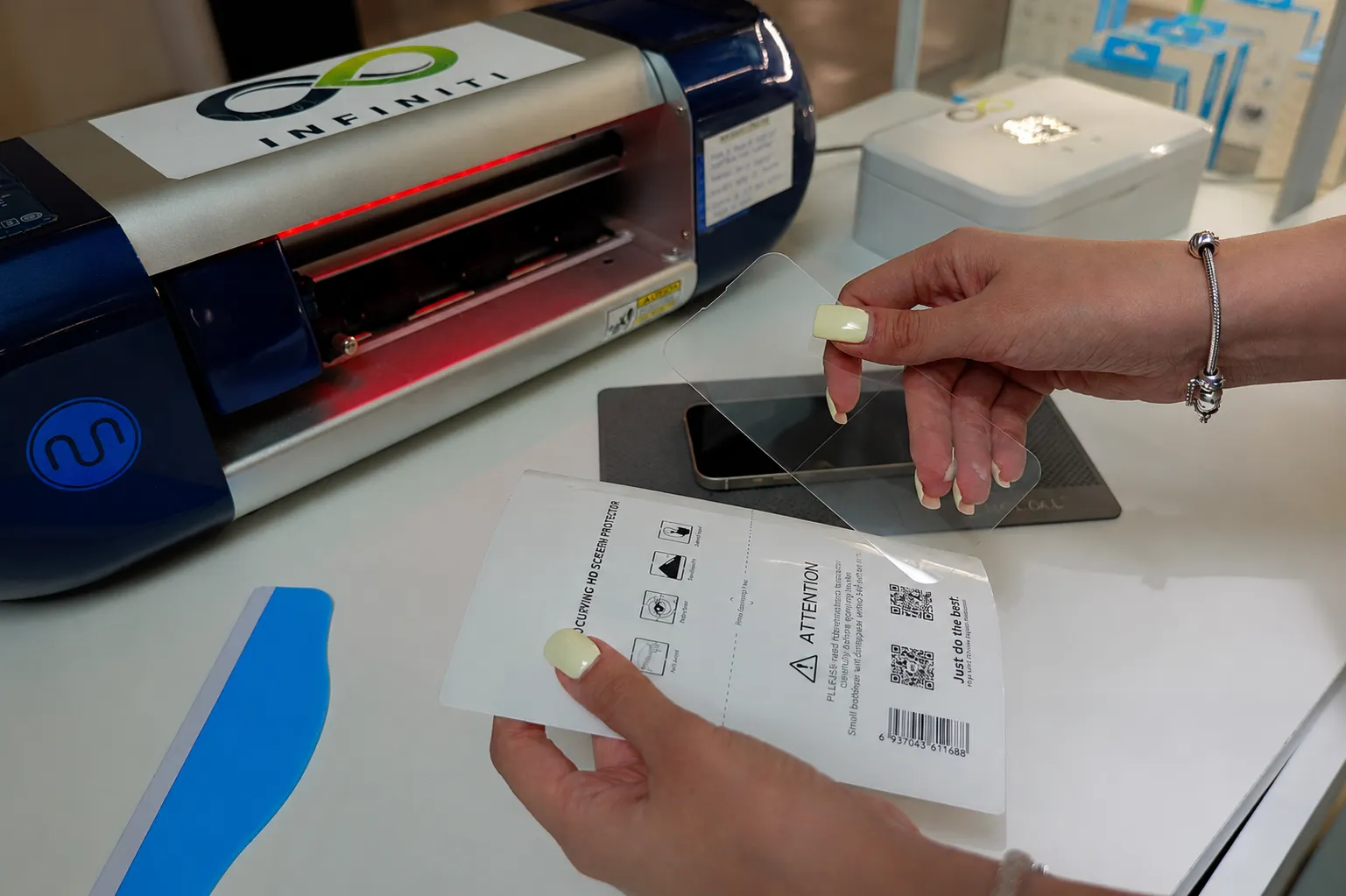 Vađenje isečenog zaštitnog stakla za telefon iz plotera pre postavke na telefon